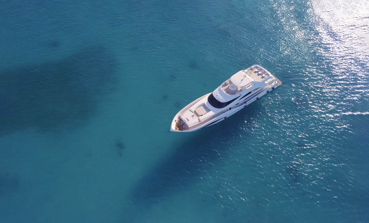 An overhead view of a yacht on turquoise water