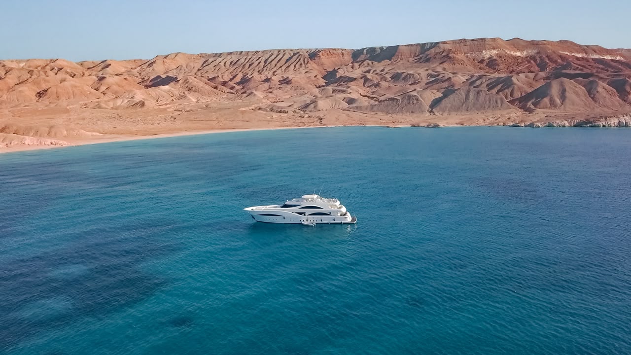A yacht on the Red Sea beside desert mountains