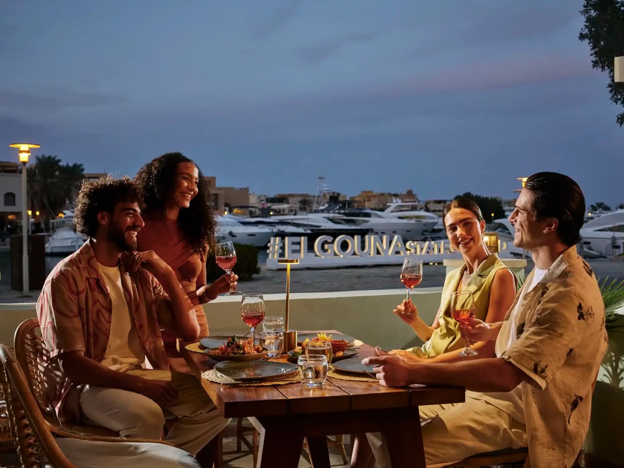Four people sharing dinner beside the marina in El Gouna